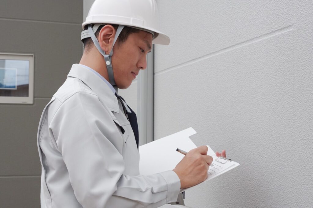 外壁のチェックをする作業員