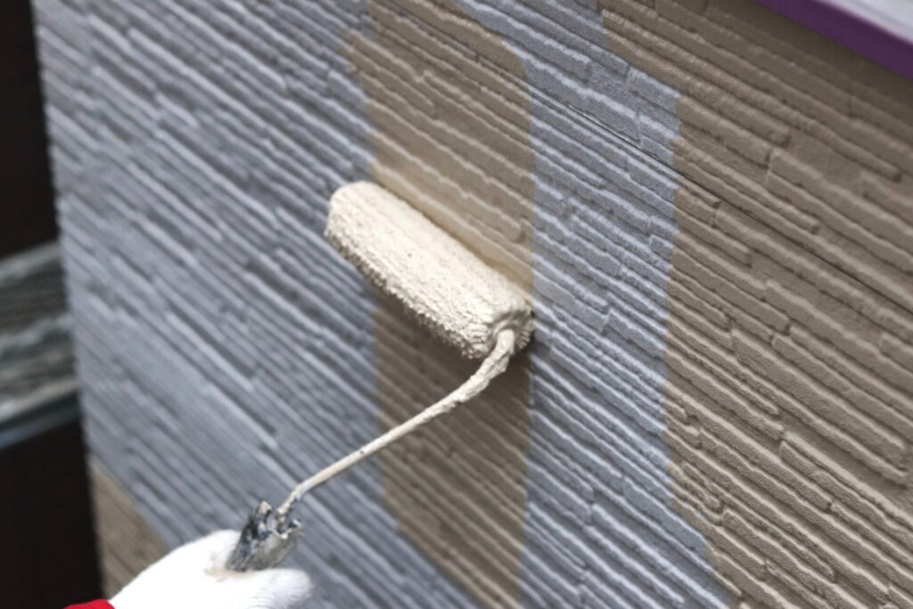 サイディング壁にローラーでシリコン塗料を塗装するイメージ