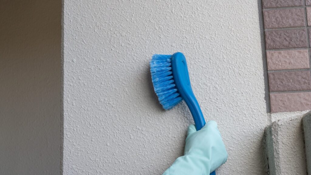 ブラシで外壁を掃除するイメージ